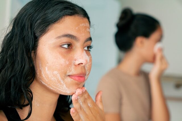 Young Latina girls wash and cleanse their skin as they look in the mirror.